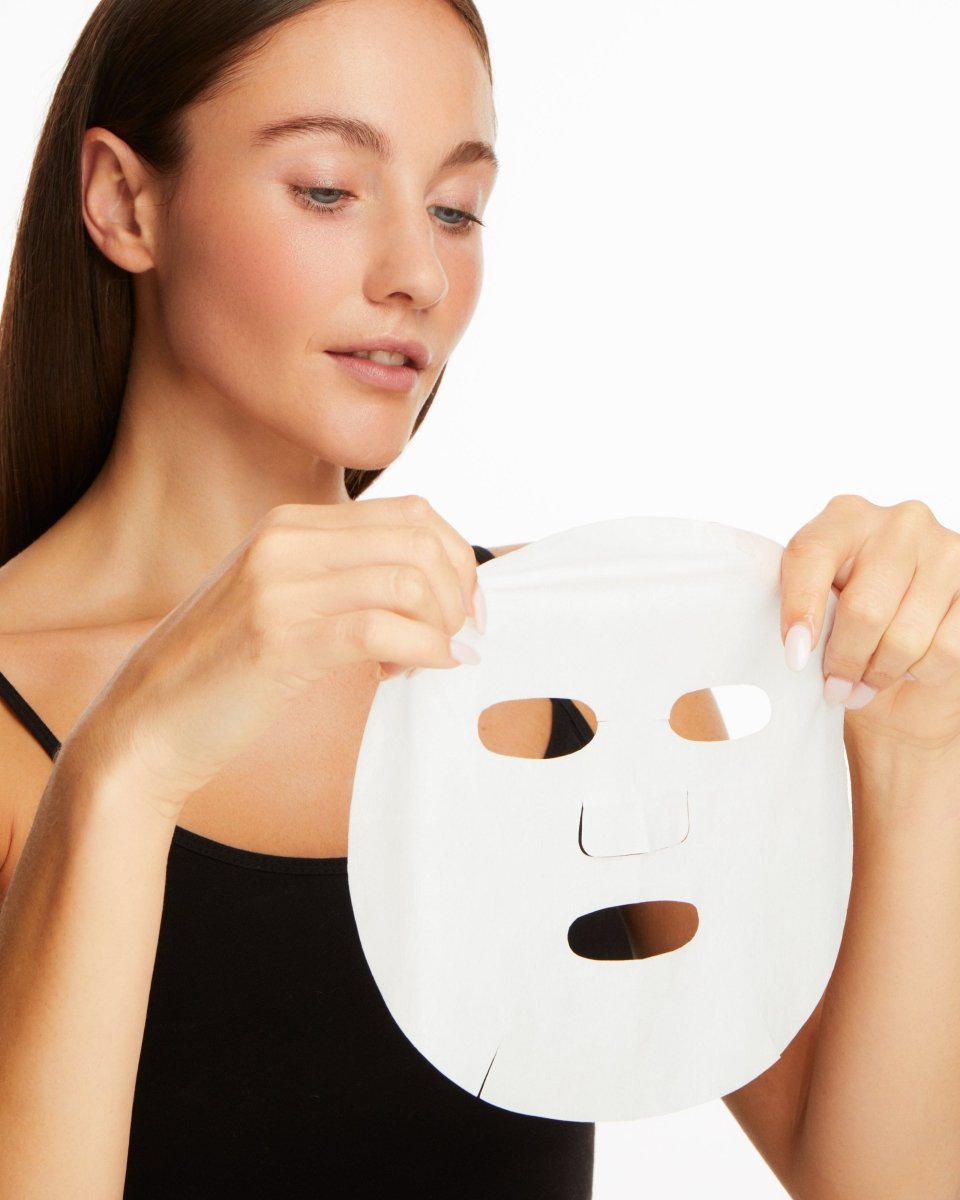 woman applying sheet mask