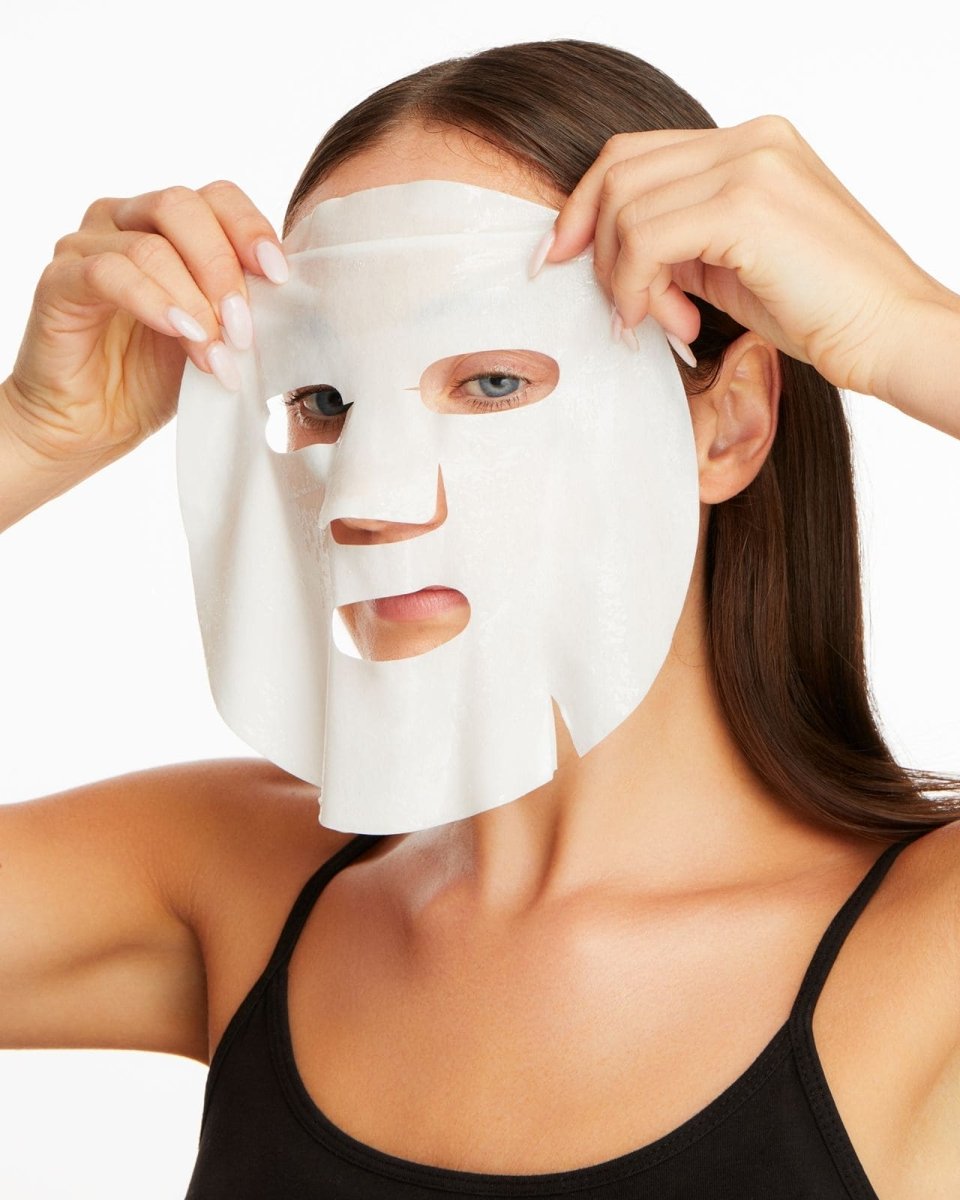 woman applying sheet mask